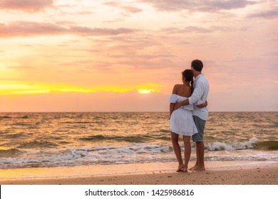 Honeymoon couple walking on sunset romantic stroll on Lover's key beach in Florida enjoying evening light relaxing on tropical summer vacation travel holiday. Two adults silhouettes lifestyle.
