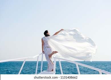 Honeymoon sea cruise. Things consider for wedding abroad. Wedding ceremony sea cruise. Bride adorable white wedding dress sunny day posing on boat or ship. Advice and tips from wedding abroad experts.