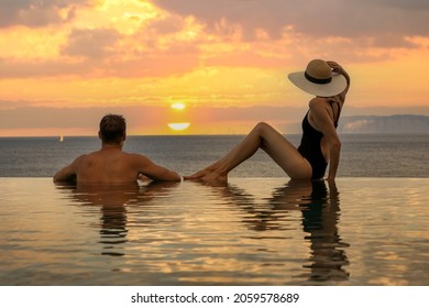 honeymoon vacation - couple enjoying romantic sunset in infinity pool at luxury resort - Powered by Shutterstock
