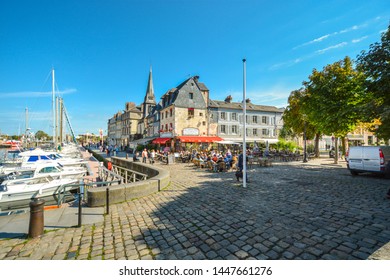 Honfleur, France - September 18 2018: A Busy Sidewalk Cafe Along The Vieux Bassin Or Old Harbor On The Normandy Coast Of France At The Medieval Fishing Village Of Honfleur, France.