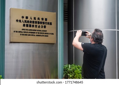 Hong Kong - 8 July 2020: Pedestrian Takes A Photo In Front Of A Plaque Outside The Office For Safeguarding National Security Of The Central People's Government In The Hong Kong.