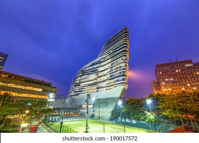 HONG KONG - APR 30, 2014: Night View Of The Jockey Club Innovation Tower. It Is Home To Hong Kong Polytechnic University's School Of Design. Designed By Pritzker-prize-winning Architect Zaha Hadid 