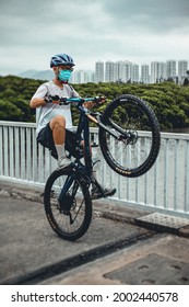 Hong Kong - April 15, 2021: Young Cyclist Doing A Wheelie On His Mountain Bike