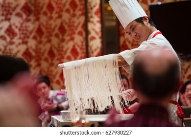 HONG KONG, APRIL 4, 2011 - Chinese Chef Showing Hand Made Noodles To Restaurant Visitors.