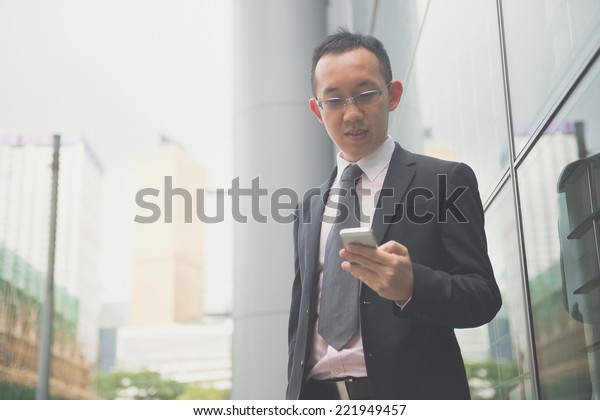 hong kong businessman in busy central district,\
light vintage blue tone\
applied