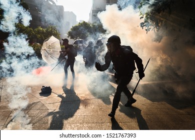 Hong Kong/ China - 1 Oct 2019: Hong Kong anti-government protestors surrounded by tear gas during a clash with the riot police in Wong Tai Sin. 