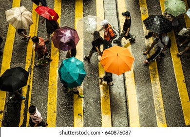 Hong Kong, China - 16 July, 2013: Top View Of People Crossing A Street In The Rain With Many Umbrellas