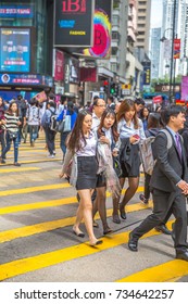 Hong Kong, China - December 6, 2016: Three Teenagers At Causeway  Bay Crosswalk On Hennessy Road, Of The Yee Wo Street, The Best Destination For Shopping, Fashion, Urban Luxury And Travel In Asia.