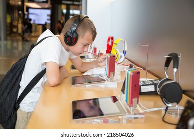 HONG KONG, CHINA - JUNE 18, 2014: The boy with headphones in Apple store in Hong Kong. Store is in a shopping center IFC Mall, it is very popular with locals and tourists visiting Hong Kong.