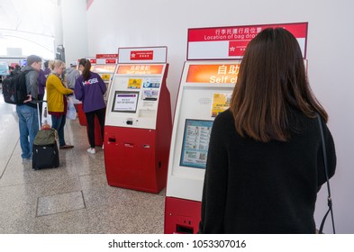 Hong Kong, China - March 19, 2018: Asian Woman And Hong Kong International Airport Staff Helping Passenger For Check-in With Kiosk Self Check-in In Terminal 1 At Hong Kong International Airport.