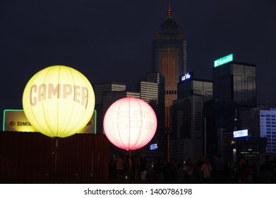 Hong Kong, China - November 27 2016: People Enjoying Music At Hong Kong Clockenflap Music Festival Silent Disco Stage Sponsored Camper. Skyscrapers And Billboards Of LG, Manulife, Somersby In Sunset