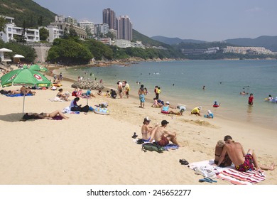 HONG KONG, CHINA - SEPTEMBER 16, 2012: Unidentified tourists sunbathe at the Stanley town beach in Hong Kong, China.