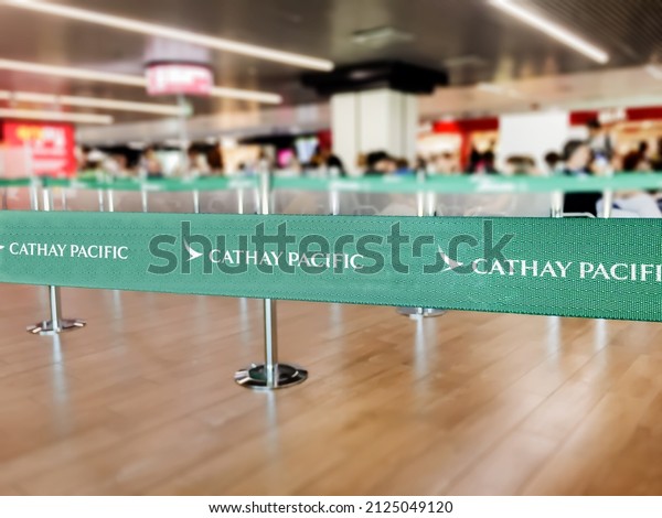 Hong Kong, CHN, July\
2019: Green belt barrier with white Cathay Pacific airlines logo.\
Cathay Pacific is the flag carrier airline of Hong Kong. Travel and\
airport security