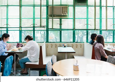 HONG KONG - CIRCA APRIL, 2017: People Are Eating Their Meal In Retro Cafe In Mong Kok. Mong Kok Is The Area That Mixed Of Vintage Old Town And New Shopping Shop With Colorful Neon Sign.