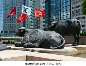 HONG KONG CIRCA JUNE 2018. Bull Sculptures And Flags Flying Outside Exchange Square, Home Of The Hong Kong Stock Exchange Which Is Currently The Third Largest Stock Exchange In Asia.