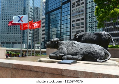 HONG KONG CIRCA JUNE 2018. Bull sculptures and flags flying outside Exchange Square, home of the Hong Kong Stock Exchange which is currently the third largest stock exchange in Asia.