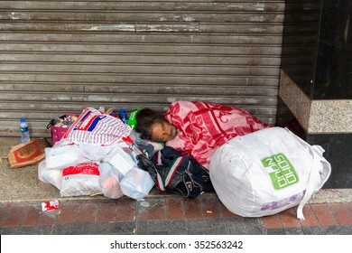 HONG KONG - DEC 13: Homeless Man Sleeping Live In Sidewalk Nathan Road, Jordan District December 13, 2014.There Isn't Enough Welfare Program Of HK Governement To Help The Poor.