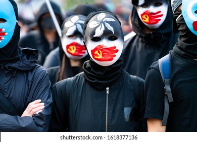 HONG KONG - DECEMBER 22 2019: A Group Of Protestors Wear Masks Symbolizing The Communist Party Of China's Silencing Of Uyghur Muslims And The Hong Kong Pro-democracy Movement At A Rally In Hong Kong.