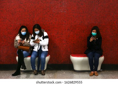 Hong Kong - January 27, 2020: Passengers Of The MTR Patiently Wait For The Subway As They Play With Their Phones, Wearing Face Masks Following Reports Of The Wuhan Coronavirus Appearing In Hong Kong.