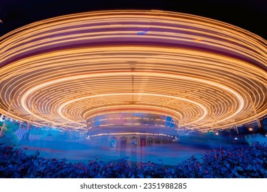 HONG KONG - 19 de mayo de 2023: Escena nocturna del carrusel Spinning Merry Go Round en DisneyLand. Baja velocidad de obturación. borroso