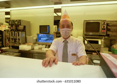 HONG KONG - OCTOBER 25, 2015: Indoor Portrait Of A Worker With Face Mask At Cafe De Coral Restaurant. Cafe De Coral Is A Fast Food Franchise Based In Hong Kong.