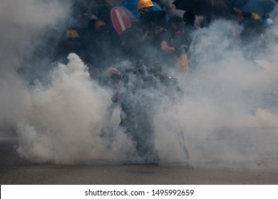 Hong Kong Protestor Picking Up A Tear Gas Cannister