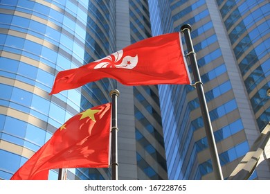 Hong Kong Regional Flag And China Flag In The Wind With Building Background