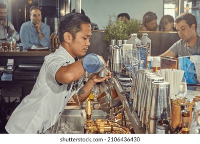 HONG KONG, SAR CHINA, AUGUST 2017: Young Asian Bartender Preparing His Gin And Tonic With GinMare Spanish Gin During The Competition. Pouring The Gin, Side View From The Bar.