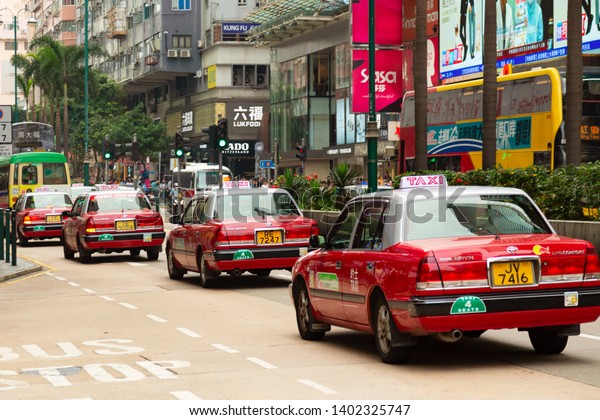 Hong Kong, SAR China - May, 2019 - Typical Hong\
Kong taxi cars. Red Toyota Crown Comfort cars in a city street\
Nathan Road.
