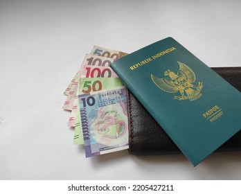 Hong Kong, September 2022 : 10.50.100.500 Hong Kong Dollar Currency Flanked By Brown Wallet And Green Indonesian Passport Book Isolated On White Background.