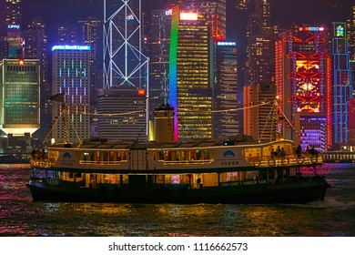 HONG KONG - September 3, 2017: Tourists Watching Symphony Of Lights Show From Deck Of Sightseeing Ferry In Multi Color Reflection Water Of Victoria Harbor With Illuminated Skyscrapers In Background