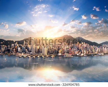 Hong Kong skyline. Hongkong hdr aerial cityscape with sunset sun. Amazing panorama of buildings and sky reflecting in harbour