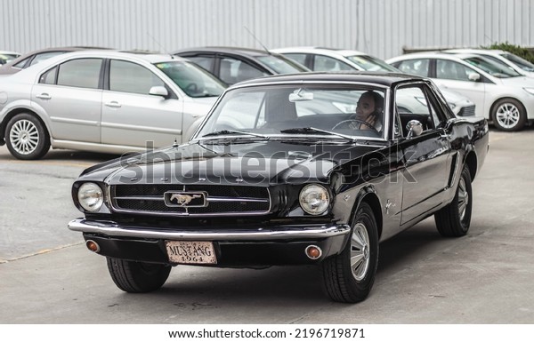 Hongkong, China- August 18,2022: a black 1964\
Ford Mustang coupe is parked in\
courtyard