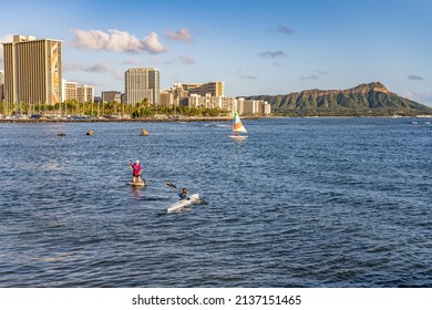 Honolulu, Hawaii - circa February 2022: People paddle board at Ala Moana Beach Park, with Diamond Head and the city skyline beyond.