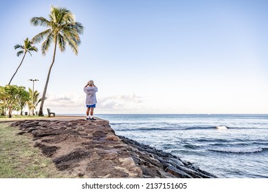 Honolulu, Hawaii - circa February 2022: A man takes photos of the beautiful scenery at Ala Moana Beach Park.