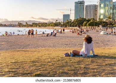 Honolulu, Hawaii - circa February 2022: People enjoy watching the sunset at at Ala Moana Beach Park.