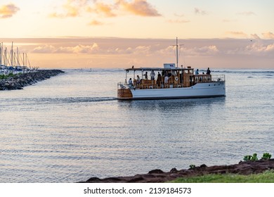 Honolulu, Hawaii - circa February 2022: A beautiful boat sailing into the horizon at sunset, at Ala Moana harbor.