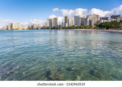 Honolulu, Hawaii - circa February 2022: The beautiful city skyline from Ala Moana harbor, beyond a view of the ocean in the foreground.