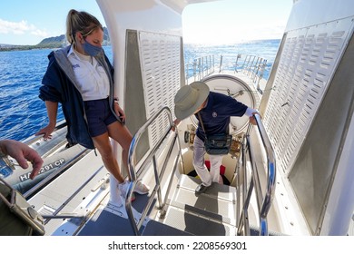 Honolulu, Hawaii - February 10, 2022 : Tourist Climbing Down A Ladder Through The Airlock Of A Submarine In Honolulu, Hawaii - Crew Member Wearing A Face Mask On A Submersible Ship