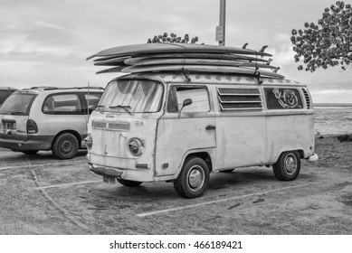 Honolulu, Hawaii, USA, August 9, 2016:  Vintage Surfing Van With Roof Top Collection Of Old Style Surfboards With Waikiki Surf In The Background.