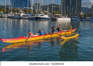 Honolulu, Hawaii, USA. Jan 10, 2017:  Hawaiian outrigger canoe and team paddling through the Ala Wai Harbor on a warm winter morning.