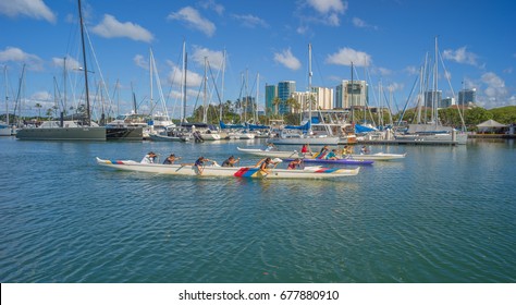 Honolulu, Hawaii, USA, July 15, 2017:  Ladies Hawaiian outrigger canoe teams racing up the Ala Wai Canal with the Waikiki Yacht Club in the background.