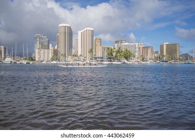 Honolulu, Hawaii, USA, June 26, 2016:  Offshore view of an outrigger canoe and team practicing for the upcoming Hawaii State Outrigger Canoe Races with Waikiki hotels in the background.