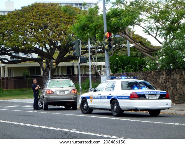 HONOLULU - MAY 3:  Honolulu\
Police Department police officer pulls over SUV car on Vineyard\
street. The HPD officer is talking to person in car, Hawaii July 4,\
2012.