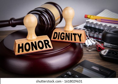 Honor and Dignity. Litigation, defense, legal services and justice concept. Wooden stamps and a hammer on the office desk - Shutterstock ID 1618029631