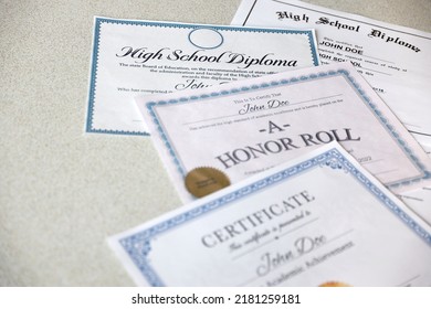 A honor roll recognition, certificate of achievement and high school diploma lies on table. Education documents close up - Powered by Shutterstock