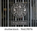 honorific emblem (text in Latin: solemnly and wisdomly) on the entrance gate of King?s College in London, public view from street