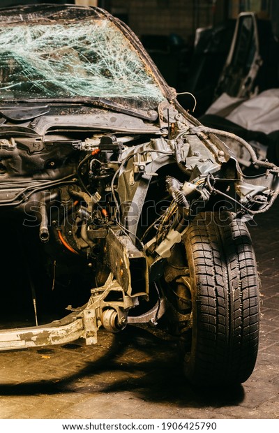 The hood of a disassembled car with a broken
windshield. Car damaged after a car accident. Dismantled engine of
a car under repair