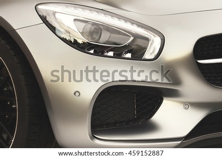 The Hood Of Modern German Sport Or Business Car With A Matte Silver Metallic  Coating, Black  Coolant Radiator Grille, Xenon  Head light, Bumper With  Park