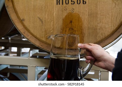 Hood River, OR - February 17, 2017: Brewer Pours Beer Out Of Wine Barrel For Tasting.